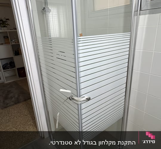 מקלחון זכוכית בחדר אמבטיה עם דלת סגורה